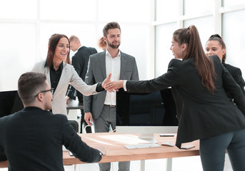 two business women greet each other with a handshake