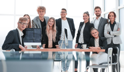 team of young professionals standing near the desktop