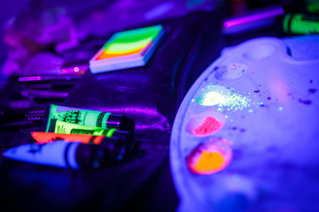 Multicolored UV fluorescent powder and paints on a palette