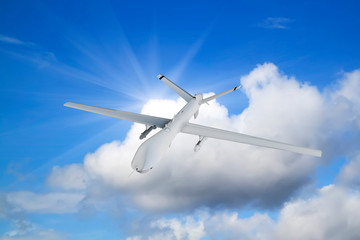 military UAV airplane drone flies against backdrop of beautiful clouds on blue sky background