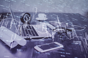 Stock market graph on background with desk and personal computer. Multi exposure. Concept of financial analysis.