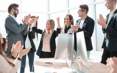 happy employees applauding at a work meeting.
