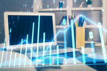 Stock market graph on background with desk and personal computer. Double exposure. Concept of financial analysis.