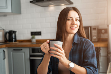 Girl in a shirt with coffee in hand.