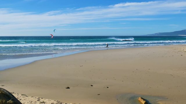The kite-surfing surfer sails on the ocean wave. Spain. Tarifa.