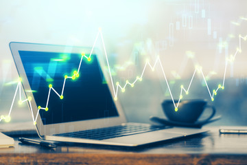 Stock market graph on background with desk and personal computer. Double exposure. Concept of financial analysis.