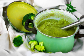 Immersion blender in pot with broccoli soup.