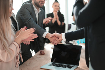 smiling businessman shaking hands with his business partner.