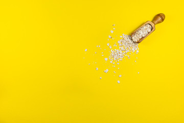 Spice scoop with oatmeal isolated on yellow background - obrazy, fototapety, plakaty
