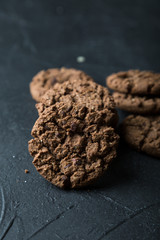 Fresh chocolate chip cookies on a dark background