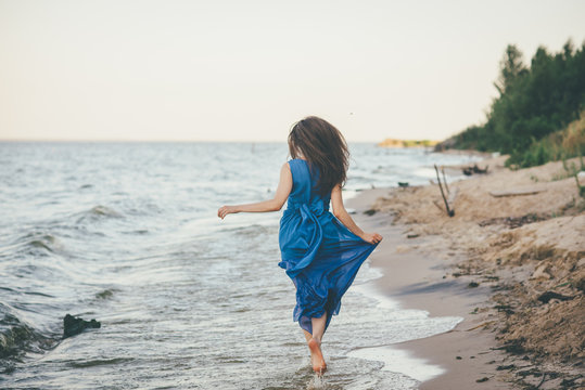 Beautiful woman walking on the beach in the water