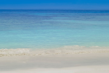 Fototapeta premium view of soft wave in blue-green sea with blue sky background, Tachai island, Mu Ko Similan National Park, Phang Nga, south of Thailand.