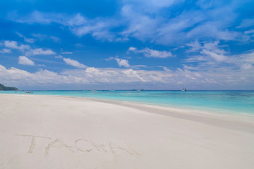 view of Tachai Text on white sand beach with blue-green sea and cloudy sky background,  Tachai island, Mu Ko Similan National Park, Phang Nga, south of Thailand.