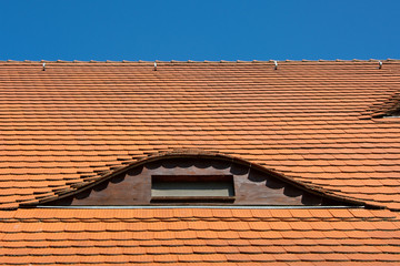 Hausdach mit roten Ziegeln und Fledermausgauben