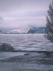 Icy landscape, blue mountains in the distance, icy desert, winter nature, ice on the river
