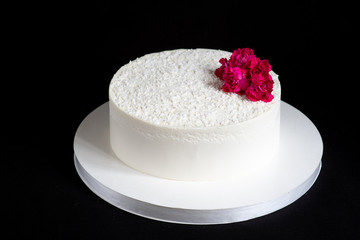 Wedding white cakes. Elegant white cake with chocolate chips and burgundy flower on isolated black bacground.