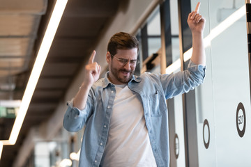 Funny millennial businessman perform winner dance in office