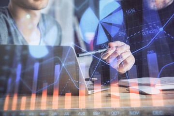 Forex graph with businessman typing on computer in office on background. Concept of analysis. Double exposure.