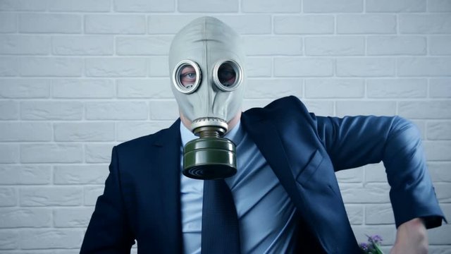 Businessman with gas mask and flowers. Ecology concept pullutiong, global warming. Lifestyle