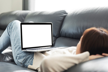 Young woman doing research work for her business, Smiling woman on sofa relaxing while browsing online shopping website, Women using laptop with blank screen at sofa.