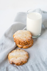 Stacked cookies on a linen napkin and a glass of milk. Close up.