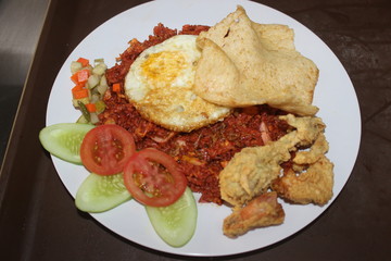 Red Fried rice or nasi goreng merah, popular traditional food from Indonesia with egg and crackers on top