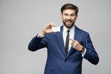 young handsome businessman holding business or credit card