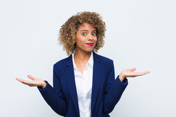 young woman african american feeling puzzled and confused, doubting, weighting or choosing...