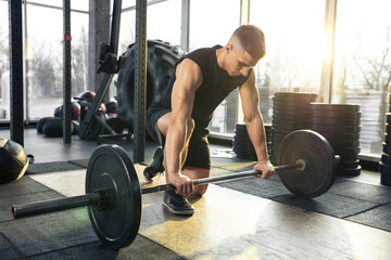 Fototapeta na wymiar Overgoing. Young muscular caucasian athlete training in gym, doing strength exercises, practicing, work on his upper body with weights and barbell. Fitness, wellness, healthy lifestyle concept.