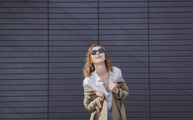 Fashion young woman wearing trendy coat and sunglasses
