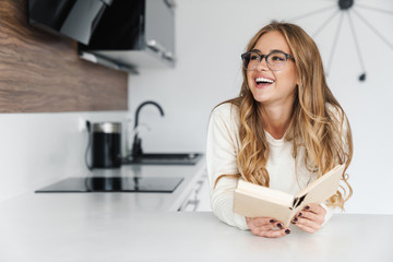 Photo of young happy woman reading book and smiling