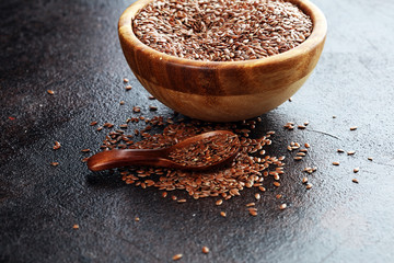Uncooked linseed in wooden spoon, rustic style. Healthy linseed