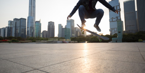 Fototapeta na wymiar Skateboarder skateboarding at sunset city