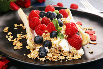 Sweet Homemade Banana Split with yogurt, granola, berries and mint. Banana Split with healthy ingredients