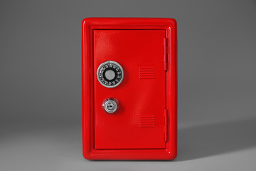 Closed red steel safe on light grey background