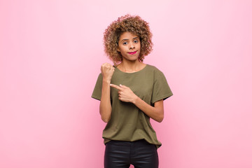 young african american woman looking impatient and angry, pointing at watch, asking for...