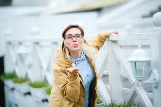 Vumen outdoors in a raincoat and glasses on the streets.