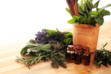 Fresh herbs from the garden and the different types of oils for massage and aromatherapy on table...