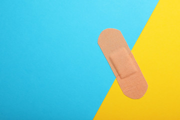 Sticking plaster on color background, top view. Space for text