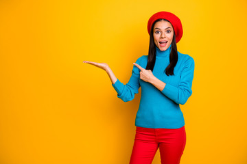 Portrait of nice attractive lovely glad amazed stunned cheerful cheery girl holding on palm demonstrating new cool good copy space isolated over bright vivid shine vibrant yellow color background