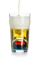 Depth charge cocktail of beer, liqueur and vodka, prepared by mixing a submerged inverted Cup at the bottom of a beer glass isolated on white. The process of filling a glass.