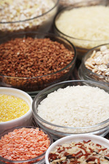 A set of bowls filled with different seeds: buckwheat, rise, corn and oatmeal	