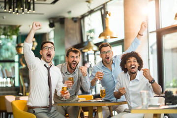 business people cheering on beer. Business people watch the game and cheer for their team