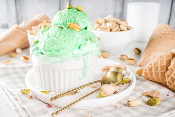 Obraz na płótnie Canvas Pistachio ice cream with nuts in white bowl