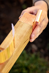 Man is affixing a copper tape on wooden beam, barrier and protection for slugs and snails