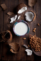 organic milk made of coconuts and almonds on rustic wooden table texture