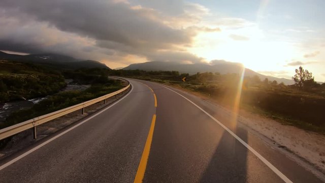 Driving a Car on a Road in Norway at dawn