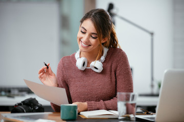 Businesswoman in office. Beautiful young woman working on paperwork at her workplace.	