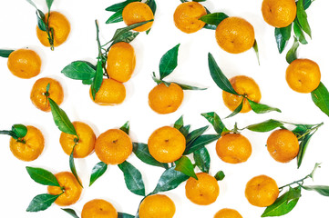 Food texture.  Fresh orange-yellow mandarin with green leaves on a white background.  Top view, flat lay.