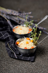 Festive french julienne with sea buckthorn in a bowl on napkin with bunch lavender on stone background. Rustic style. Baked mushroom julienne with chicken and cheese in pots. Top view. Close up
